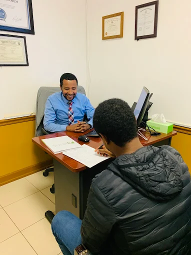 Wasyihun Workneh meeting with a client in the Brook Tax and Insurance office
